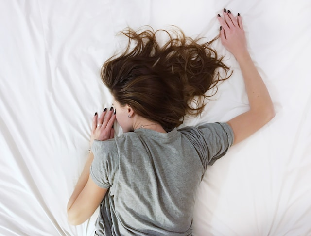Eine Frau schläft auf einem Bett.